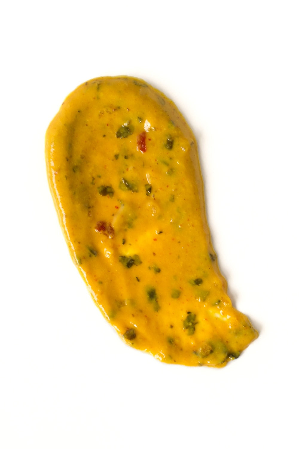 Yellow sauce with herbs on a white background