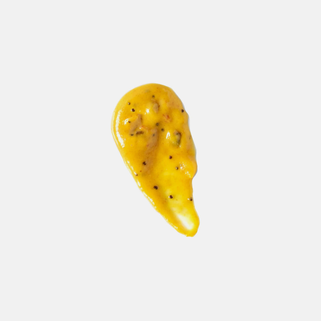 Yellow mustard smear with bubbles and pepper
